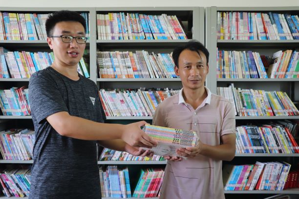 指导老师任晓东为当地小学捐献书籍与文具等.JPG