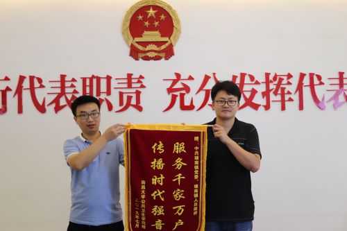 指导老师任晓东为塘南镇政府送上锦旗.jpg