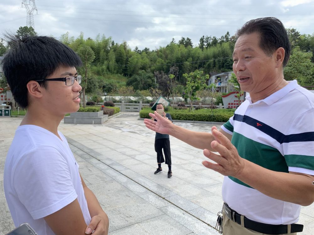 前洋村村委会副主任刘昌明向调研队员介绍前洋村近年来产业发展状况.jpg